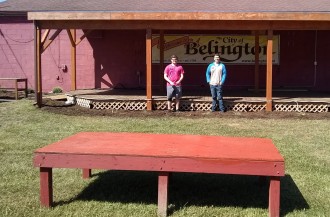 two mormon missionaries help to paint a lovcal stage